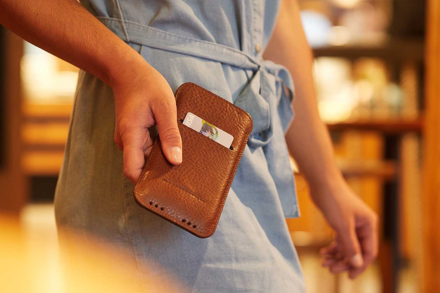 Eine Frau hält ein iPhone 12 Mini Leder Case in der Hand