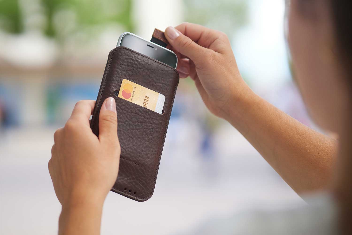 Eine Frau hält ein iPhone 13 Mini Leder Case in den Händen