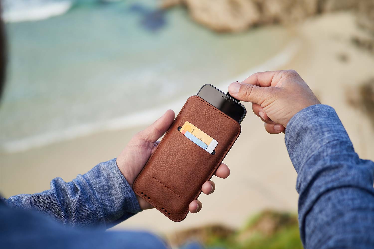 Ein Mann hält seine iPhone 14 Lederhülle in der Hand und zieht an der Lasche