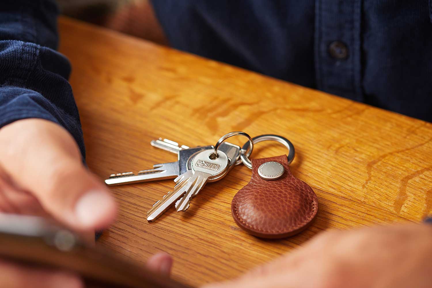 Auf einem Tisch liegt ein Airtag Schlüsselanhänger von Good Wilhelm