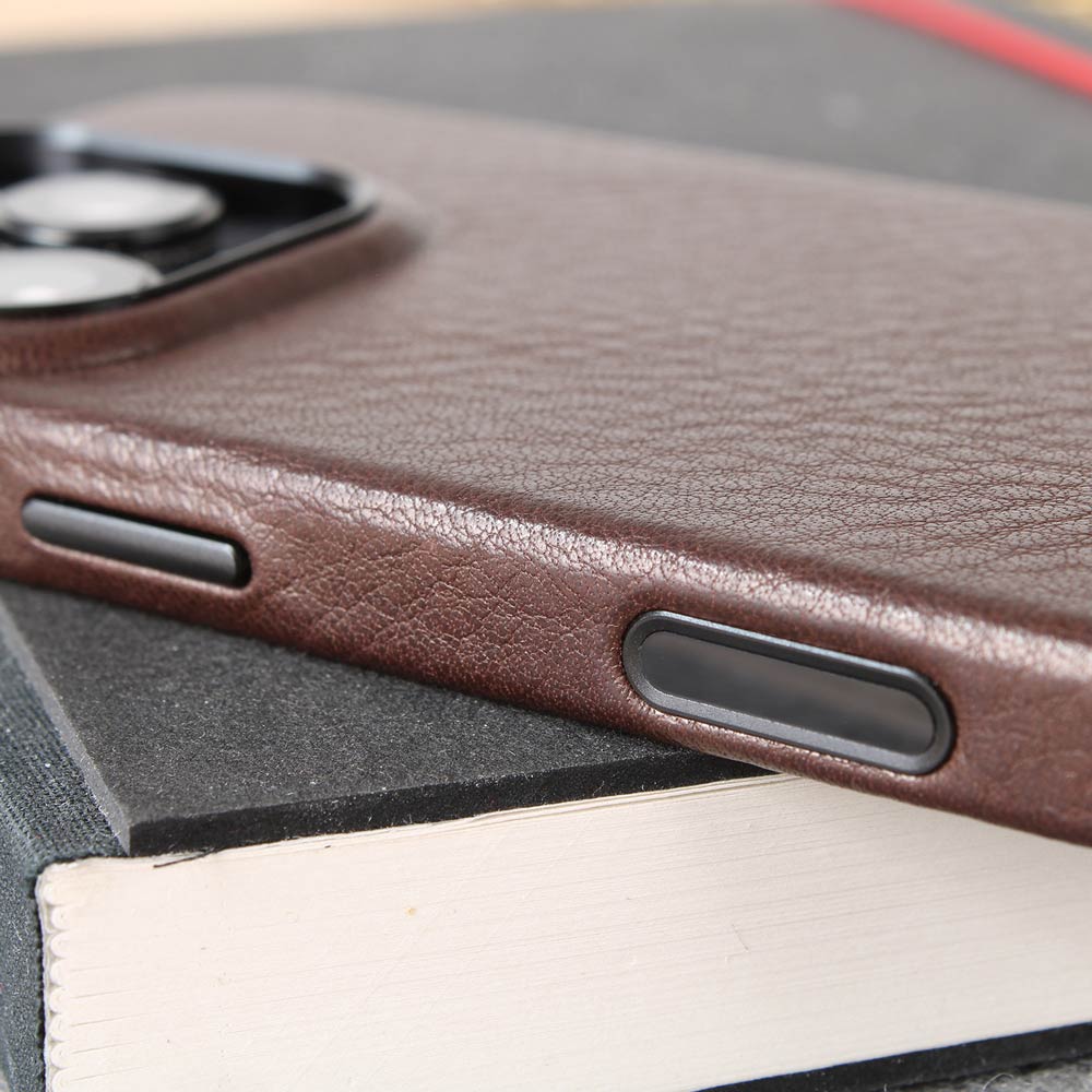Auf einem Schreibblock liegt eine hochwertige iPhone 16 Pro Hülle mit Kamerasensor Knopf aus dunkel braunem Leder von Goodwilhelm