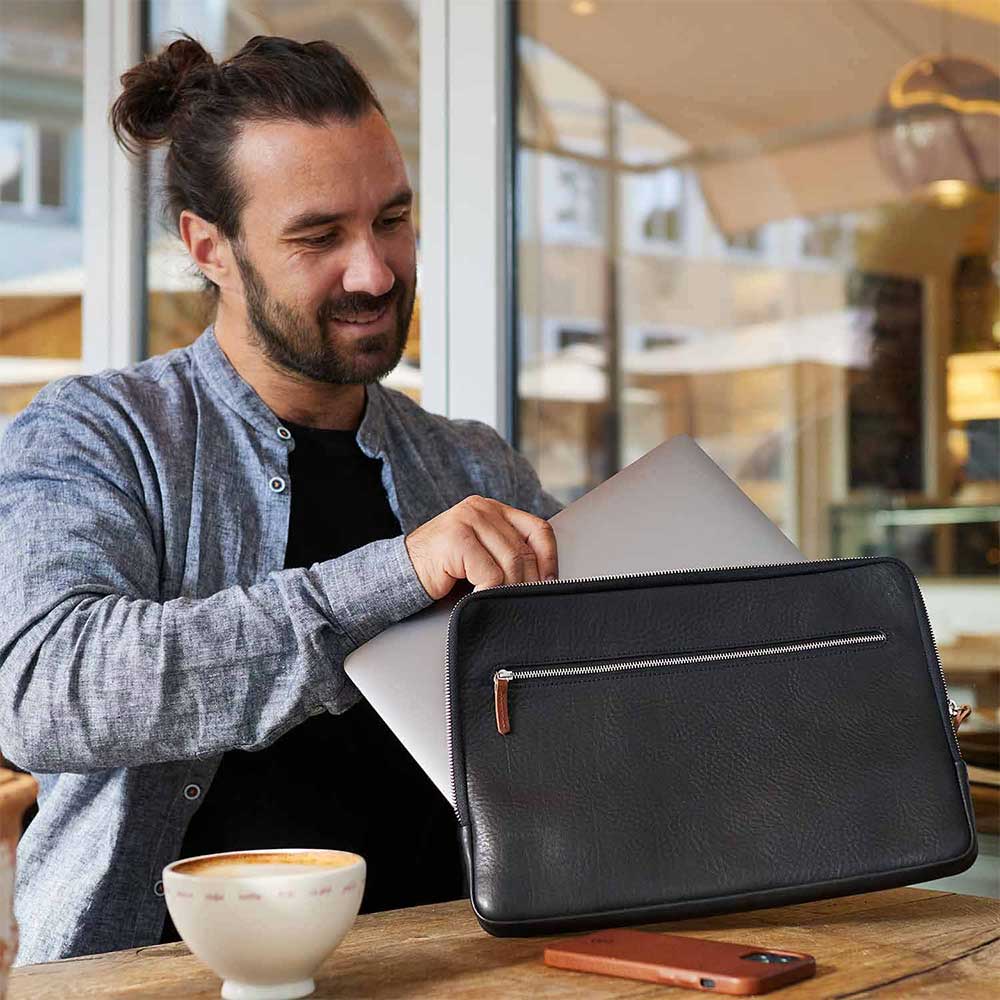 Mann mit schwarzer Macbook Hülle von Goodwilhelm