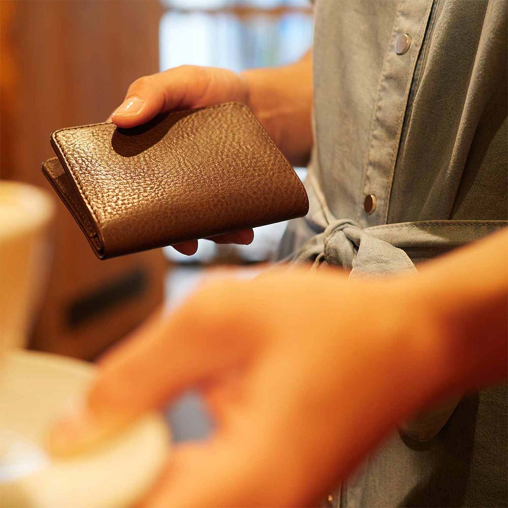 Eine Frau hält eine Lederportemonnaie in den Händen