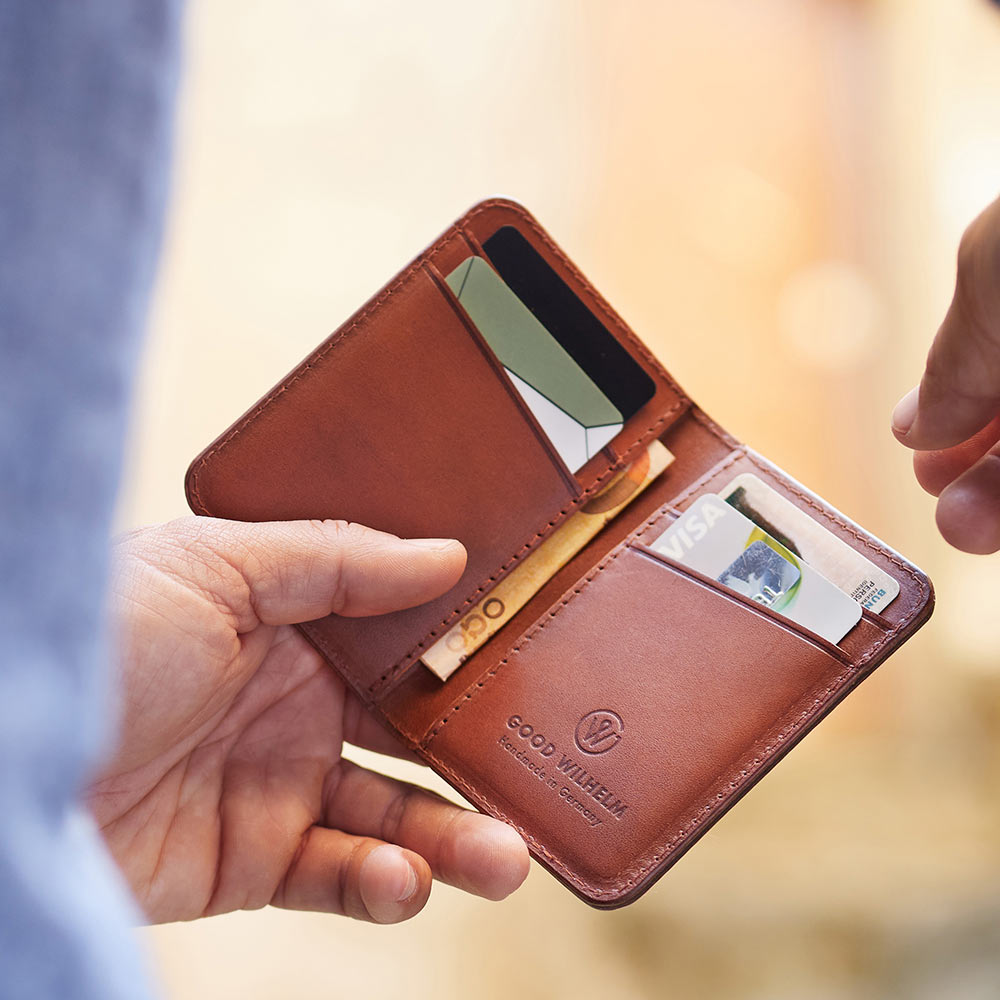 Offen gehaltene BiFold Wallet Arthur aus cognacbraunem Vacetta-Leder mit sichtbaren Kartenfächern und RFID-Schutz.
