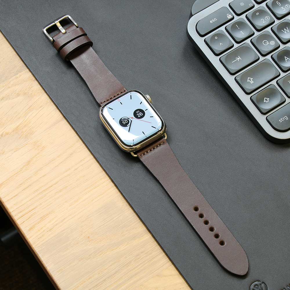 Auf einem Tisch liegt eine Apple Watch mit Lederarmband in der Farbe Chocolate von Goodwilhelm