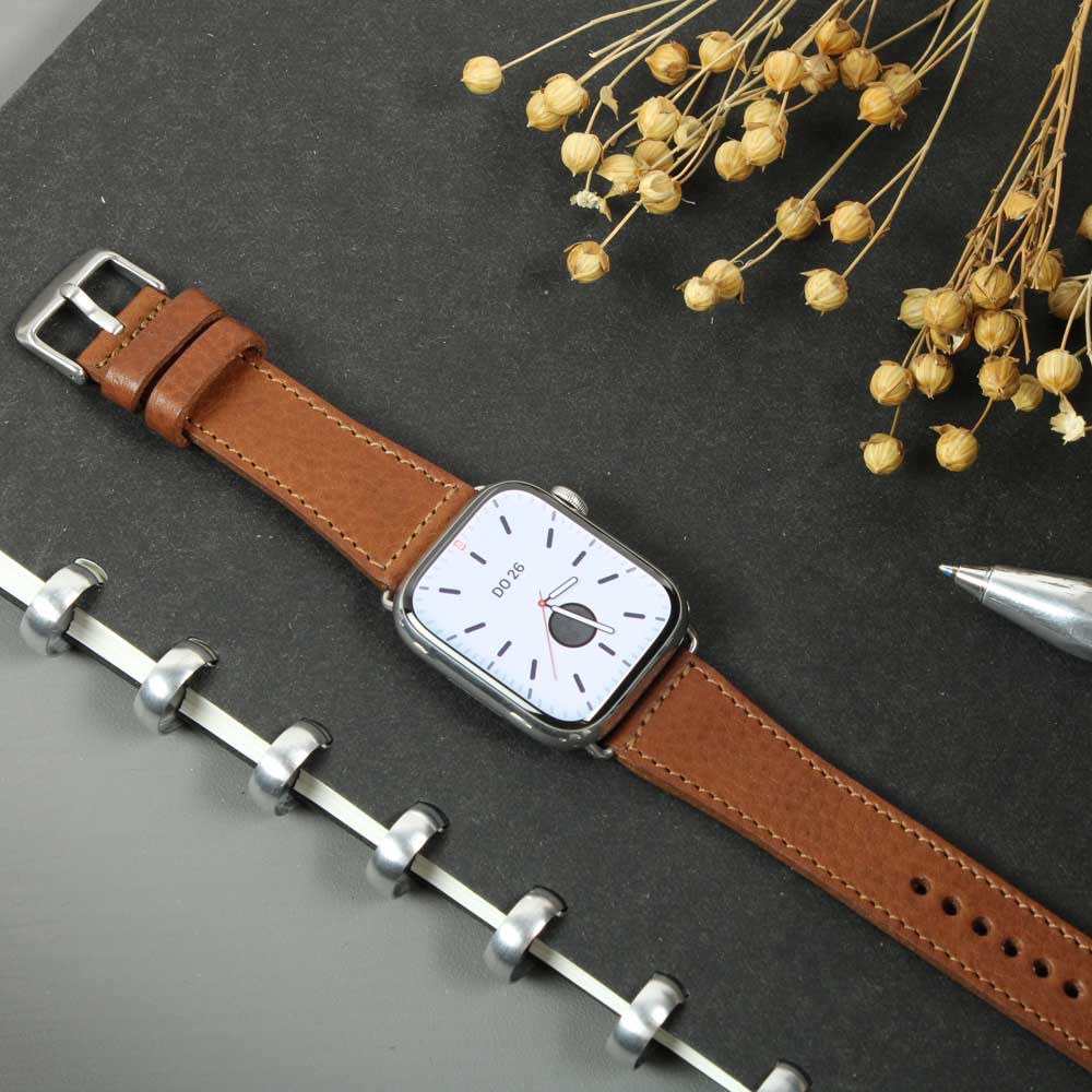 Auf einem Tisch liegt eine Uhr mit einem hellbraunem Lederarmband von Goodwilhelm