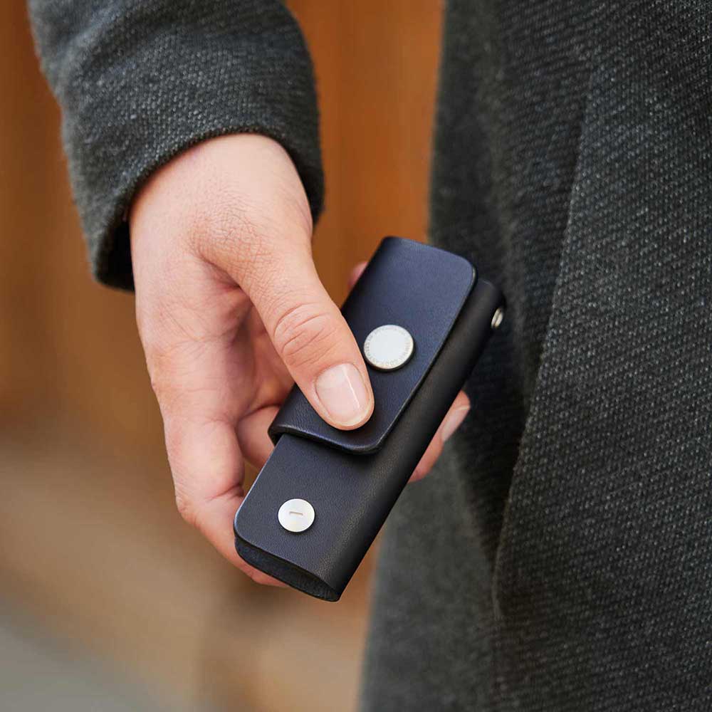 Eine Hand hält eine Schlüsseltasche in der Farbe Schwarz von Goodwilhelm in den Händen